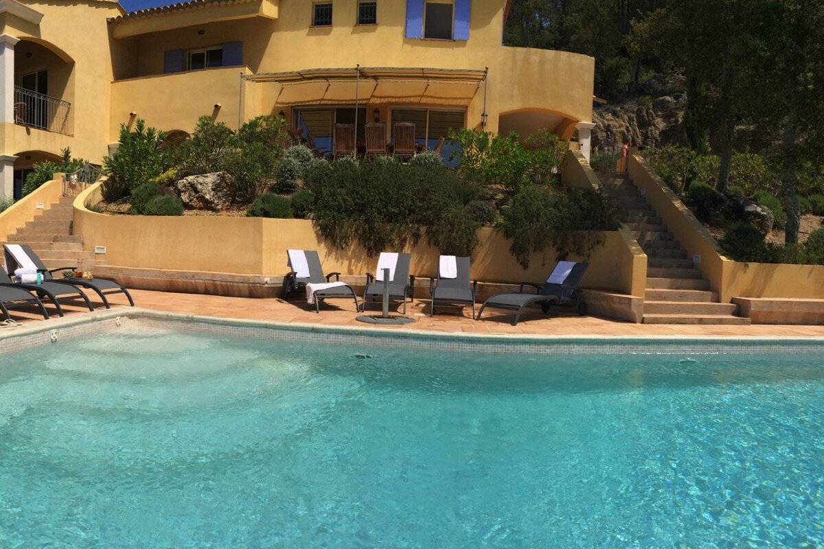 A large house with a swimming pool in front of it