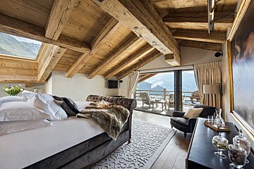 A bedroom with a large bed and a sliding glass door