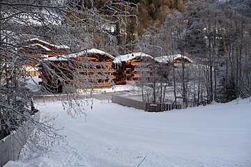 A snowy landscape with a building in the background