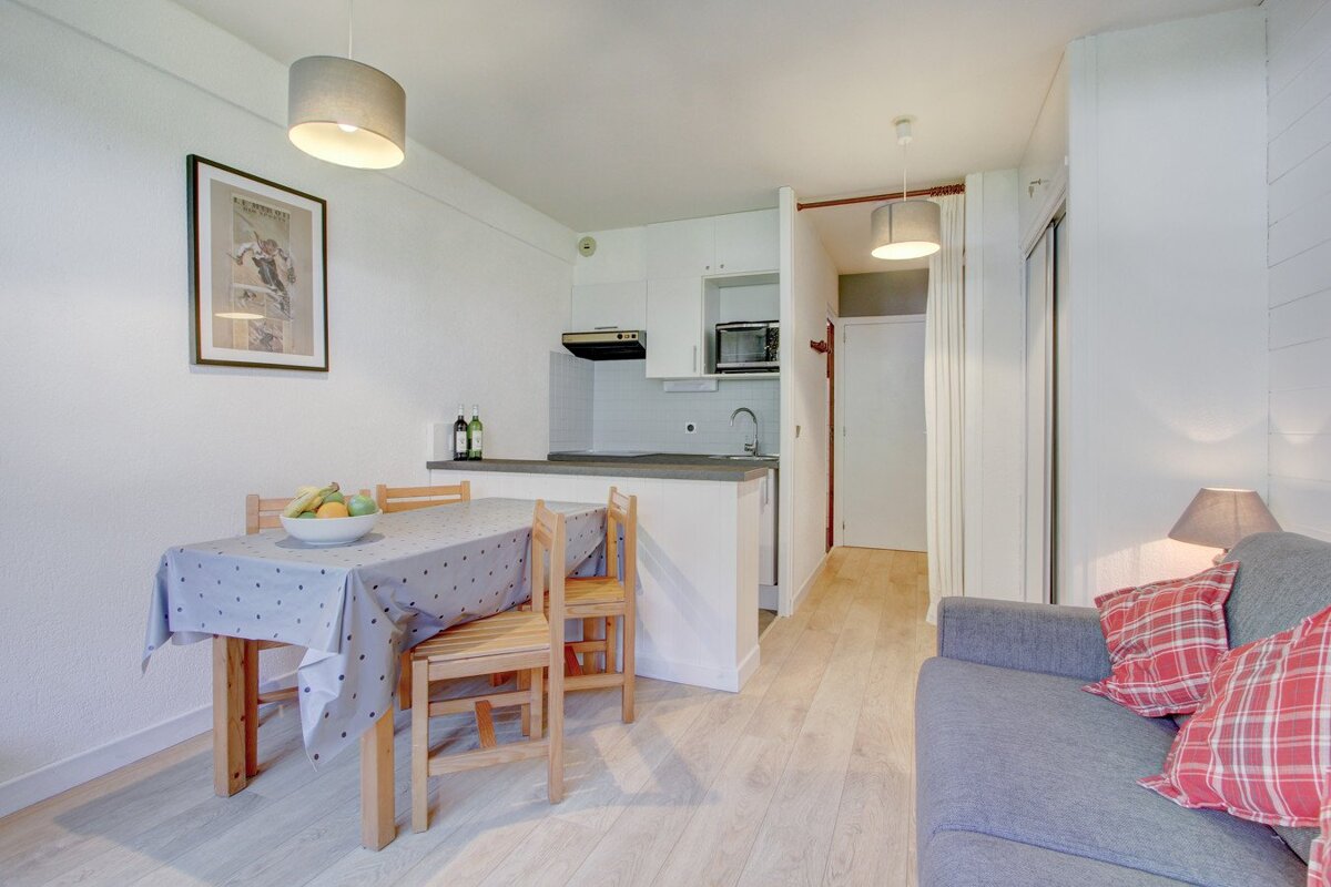 A living room with a table and chairs and a picture on the wall