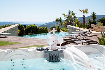 A bottle of wine sits on a holder in a hot tub