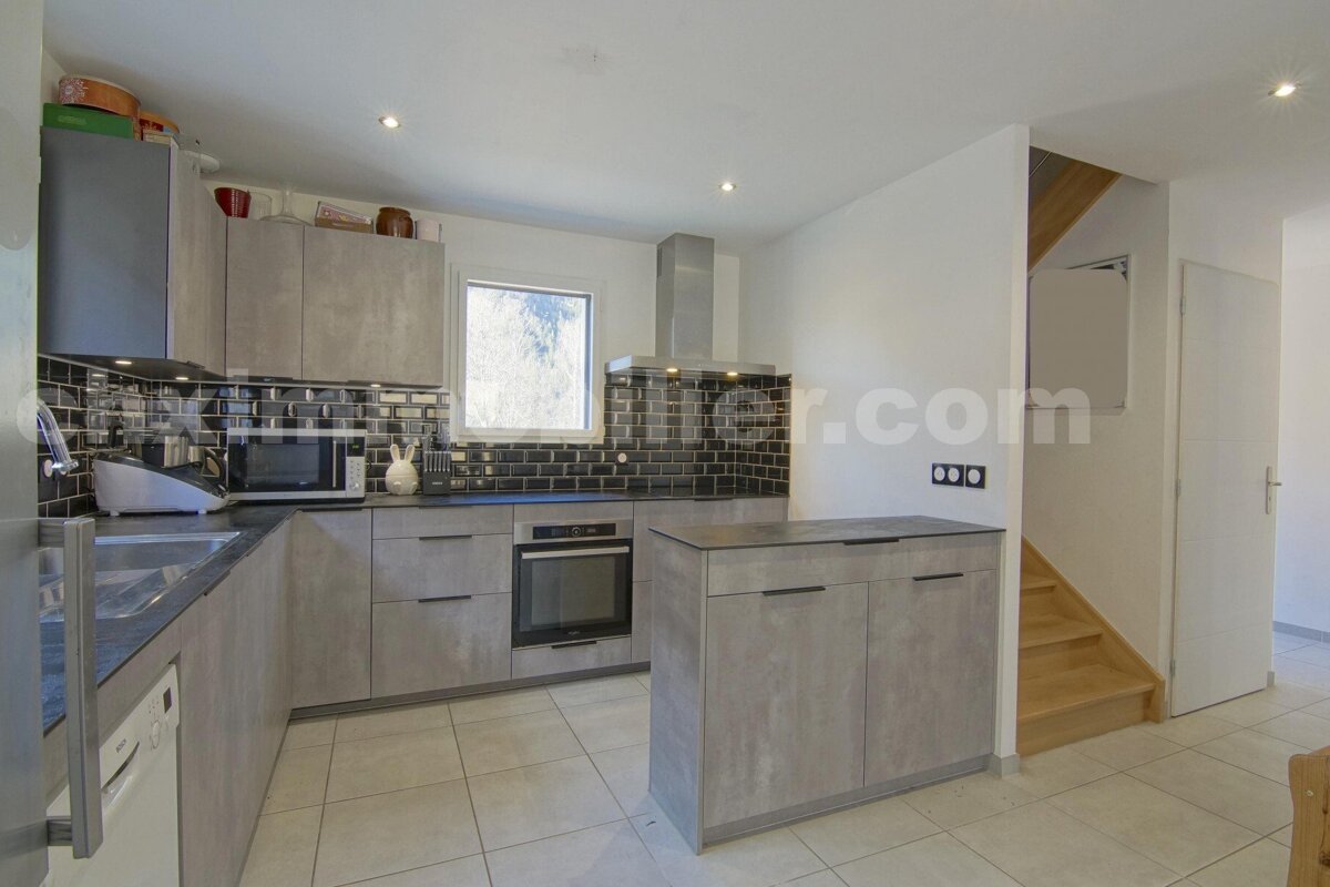 A kitchen with a staircase and a website called keller.com