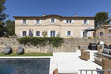 A large house with a swimming pool in front of it