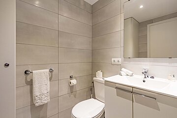 A bathroom with a toilet a sink and a mirror
