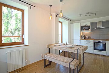 A kitchen with white cabinets and a wooden table