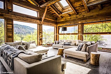 A living room with a large sectional couch and lots of windows