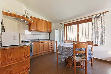 A kitchen with a table and chairs and a microwave