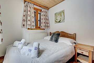 A bedroom with a bed and a picture of a rose on the wall