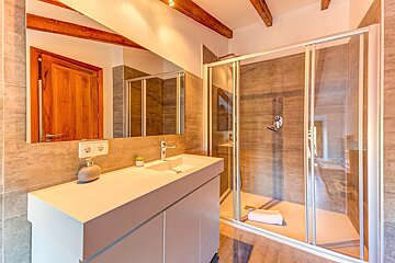 A bathroom with a sink and a walk in shower