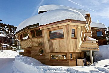 A snow covered house with a copper roof