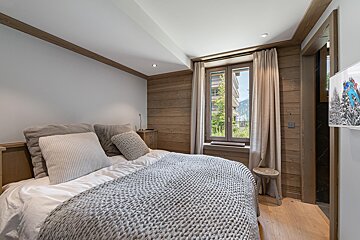 A bedroom with a knitted blanket on the bed