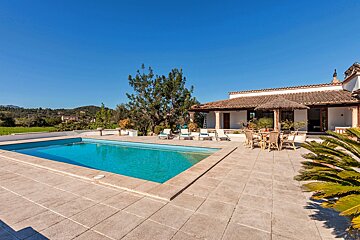 A large swimming pool in front of a house