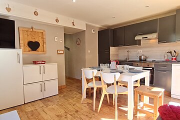 A kitchen with a white table and white chairs