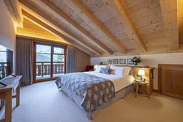 A bedroom with a king size bed and a balcony