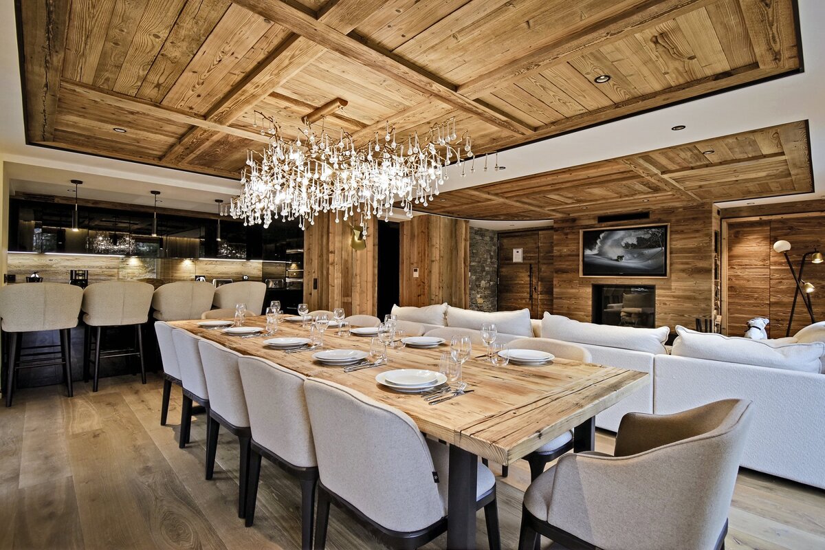 A dining room with a long wooden table and chairs