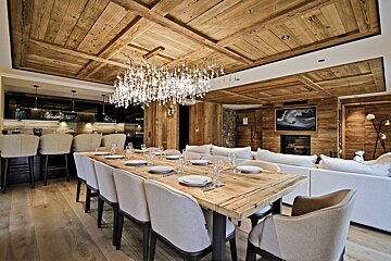 A dining room with a long wooden table and chairs