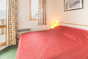 A bedroom with a bed and a picture on the wall