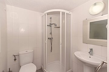 A bathroom with a toilet a sink and a shower
