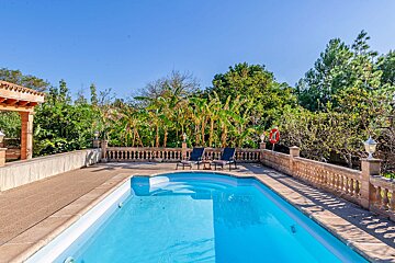 A large swimming pool surrounded by chairs and trees