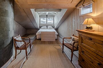 A bedroom with a wooden dresser and a wooden bench