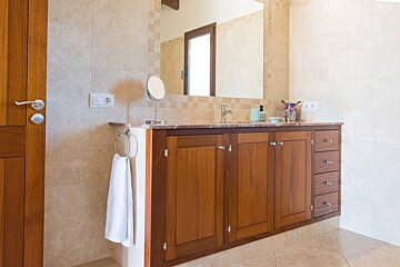 A bathroom with wooden cabinets and a mirror