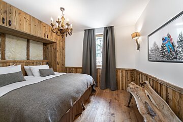A bedroom with a bed and a picture on the wall