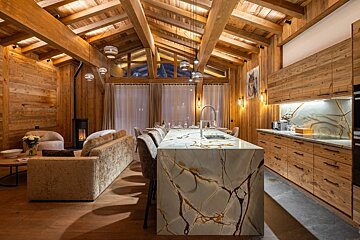A kitchen with a marble counter top and wooden cabinets