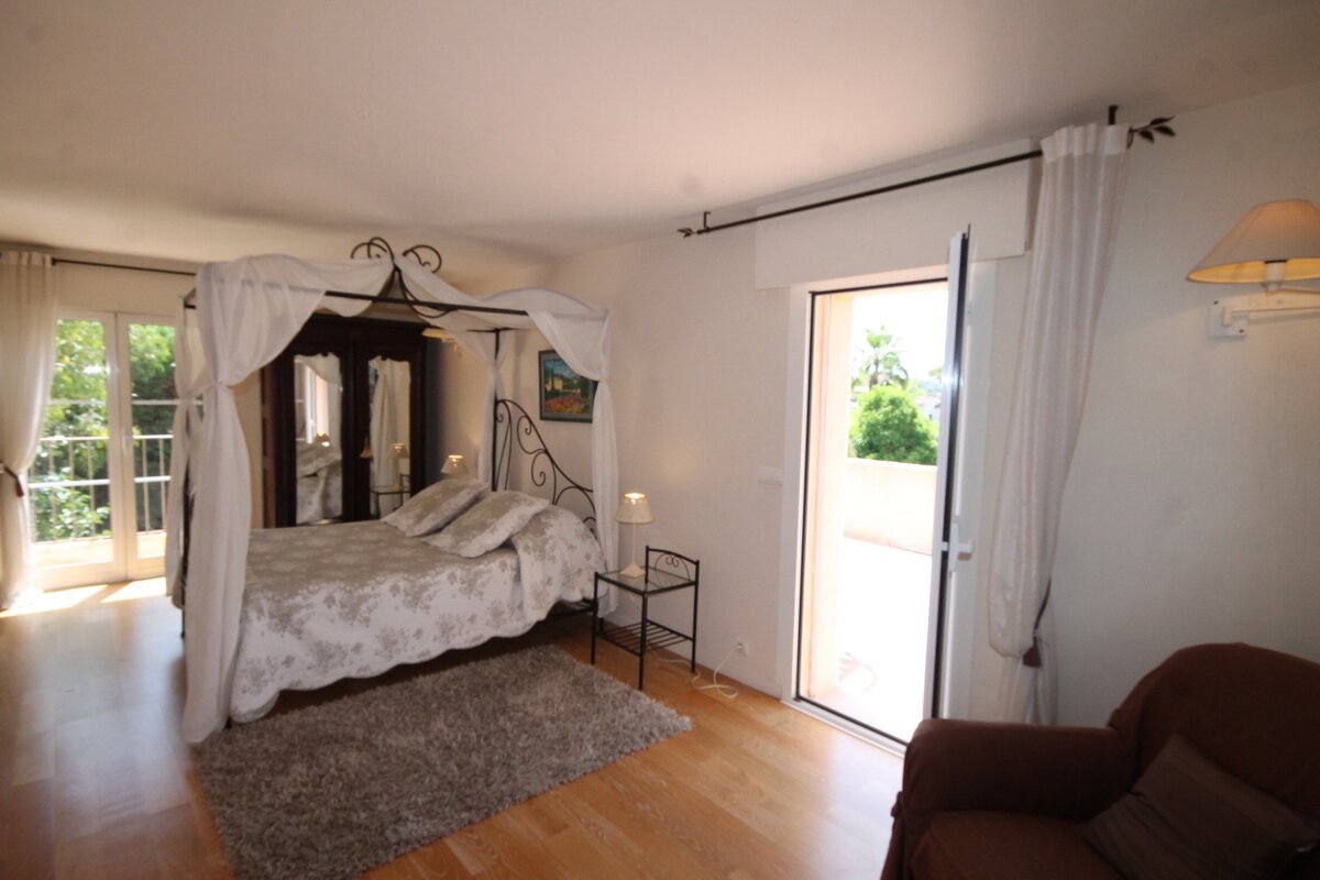 A bedroom with a canopy bed and a chair