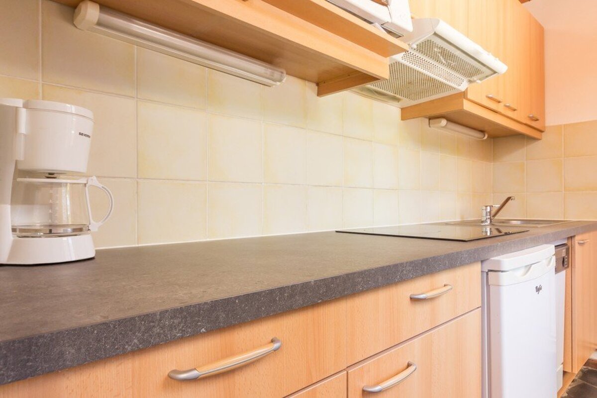 A kitchen counter with a coffee maker and a dishwasher
