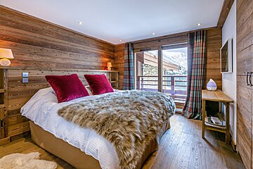 A bedroom with a bed with a fur blanket on it