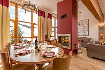 A dining room table with a bottle of wine on it