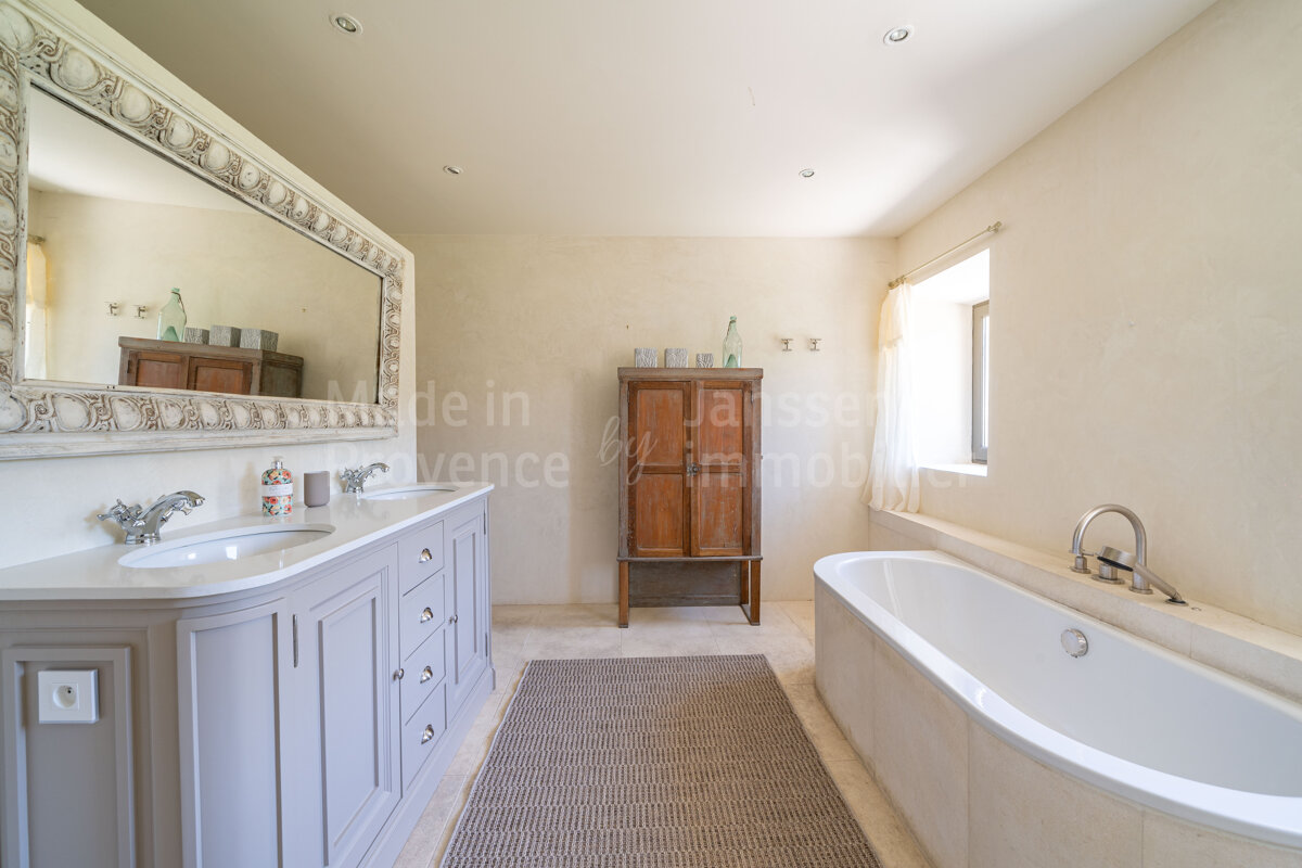 A bathroom with two sinks and a bathtub says made in provence