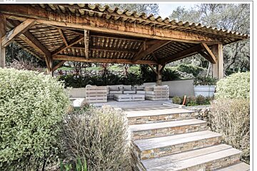 A wooden gazebo with stairs leading up to it
