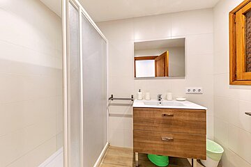 A bathroom with a sink and a green trash can