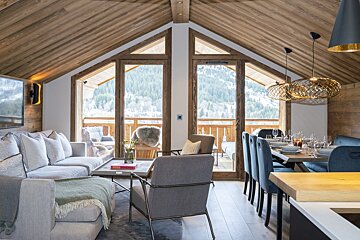 A living room with a couch and chairs and a dining table