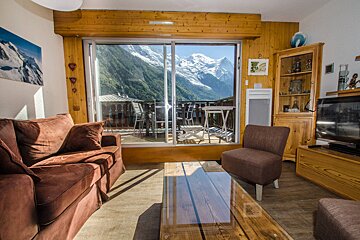A living room with a sliding glass door leading to a balcony