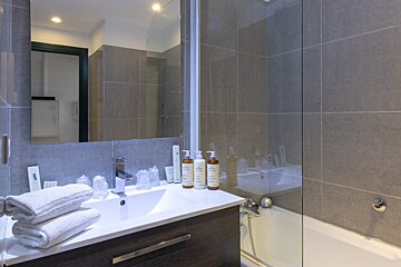 A bathroom with a sink and two bottles of shampoo on the counter