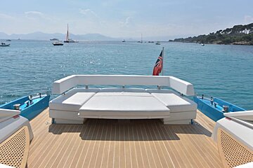 The back of a boat with a couch and a flag