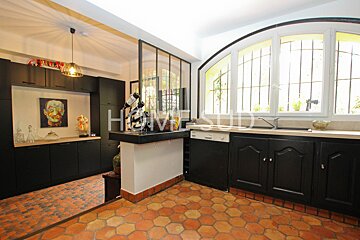A kitchen with black cabinets and a sign that says hervisud