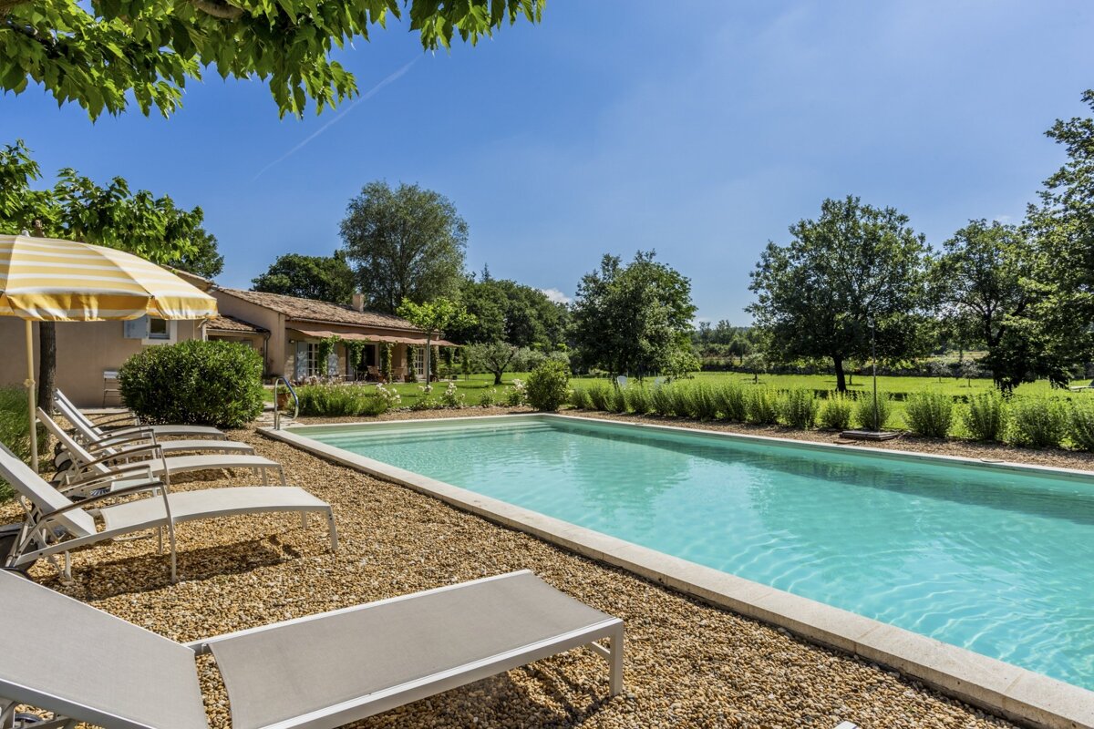 A swimming pool with a yellow and white striped umbrella