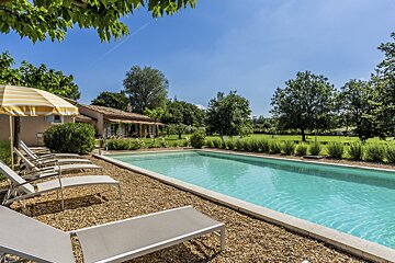 A swimming pool with a yellow and white striped umbrella