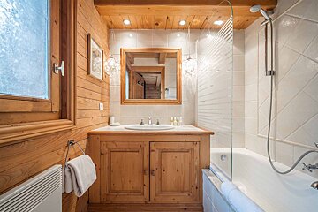 A bathroom with wooden cabinets and a bathtub