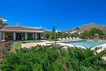 A large house with a swimming pool in front of it