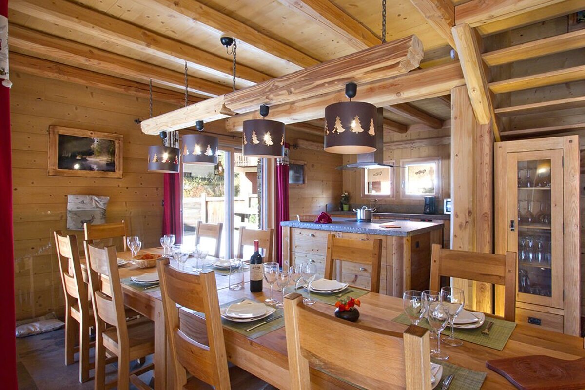 A dining room table with a bottle of wine on it