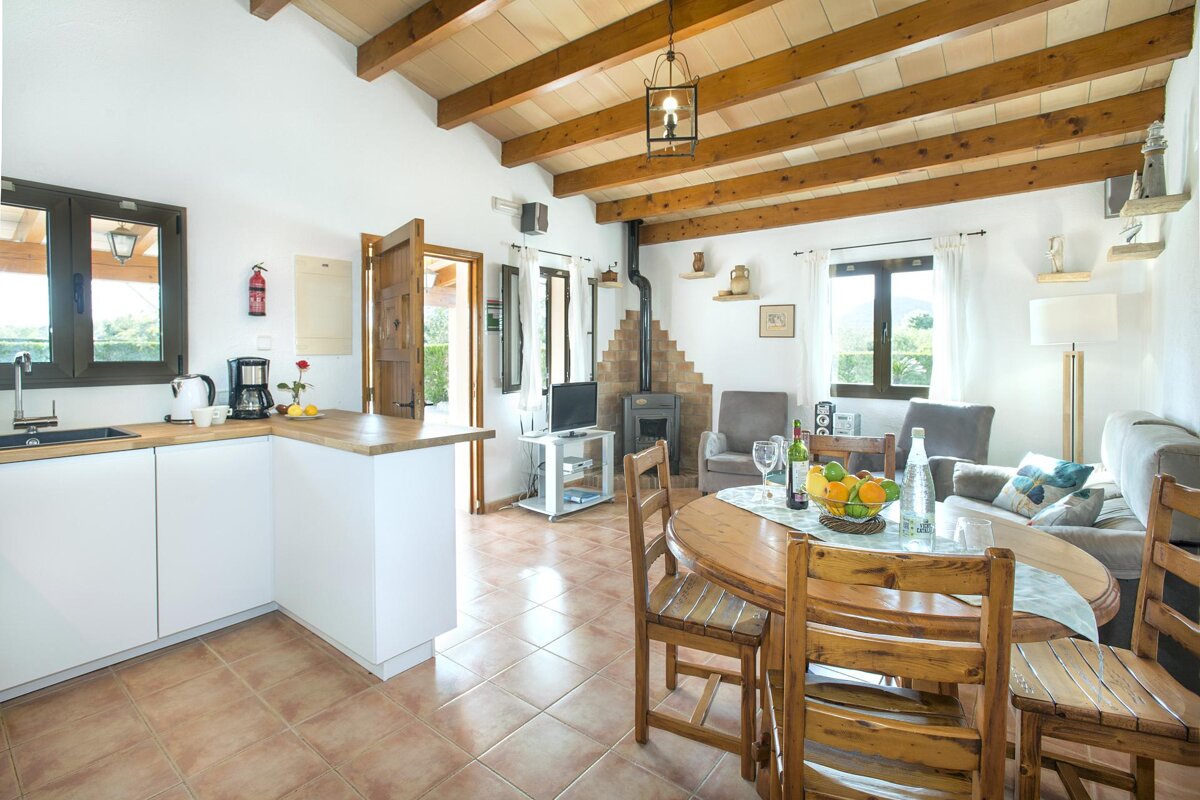 A kitchen with a table and chairs and a fire extinguisher on the wall
