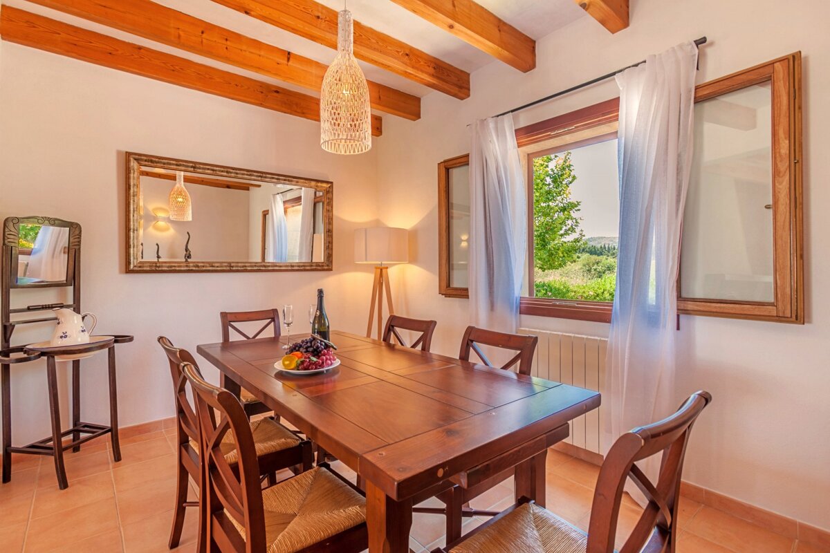 A dining room table with a bowl of fruit on it