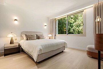 A bedroom with a large bed and a large window