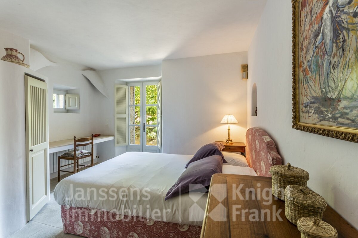 A bedroom with a large bed and a knight frank logo on the wall