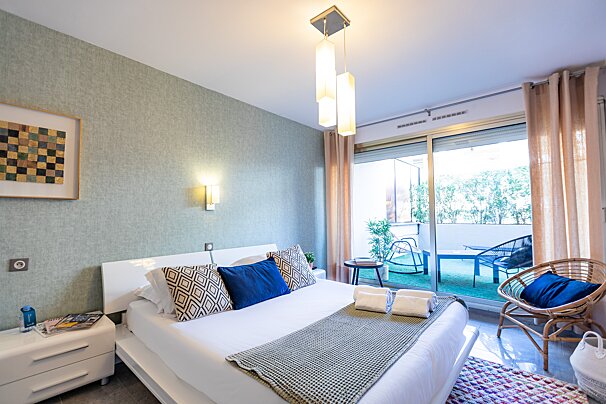 A bedroom with a sliding glass door leading to a balcony