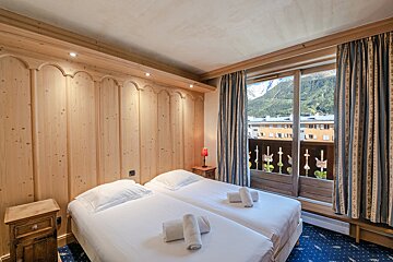 A hotel room with two beds and a balcony